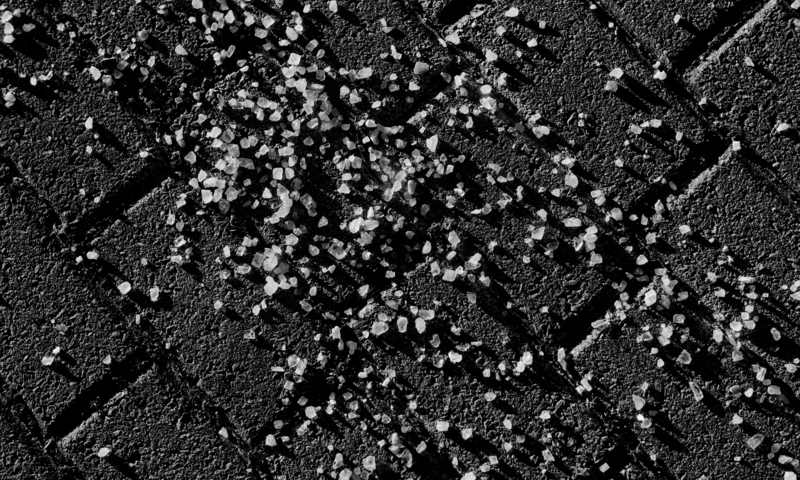 Road salt on pavement in black and white
