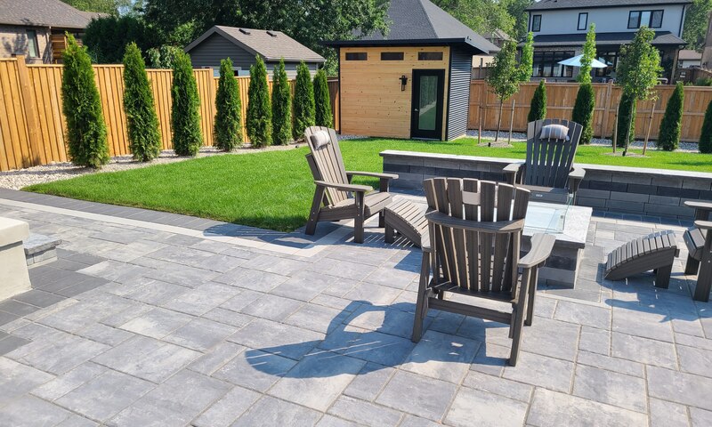 Backyard with stone patio and manicured lawn